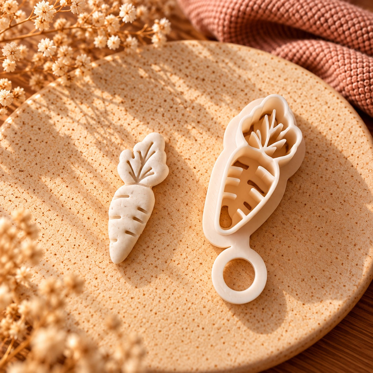 Carrot shaped cookie cutter and matching impressed fondant carrot topper on a textured stone plate.